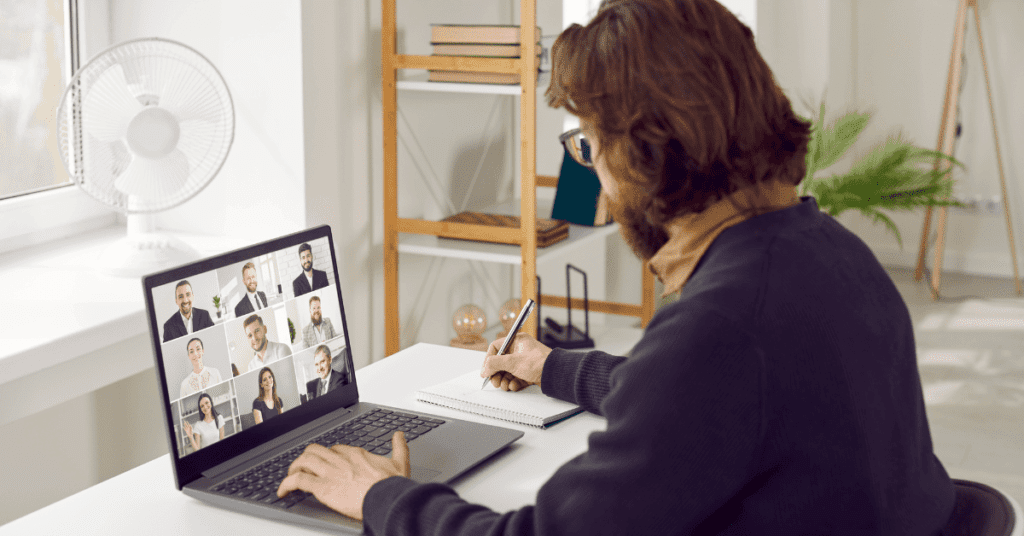 A man having a virtual meeting with his co-workers.