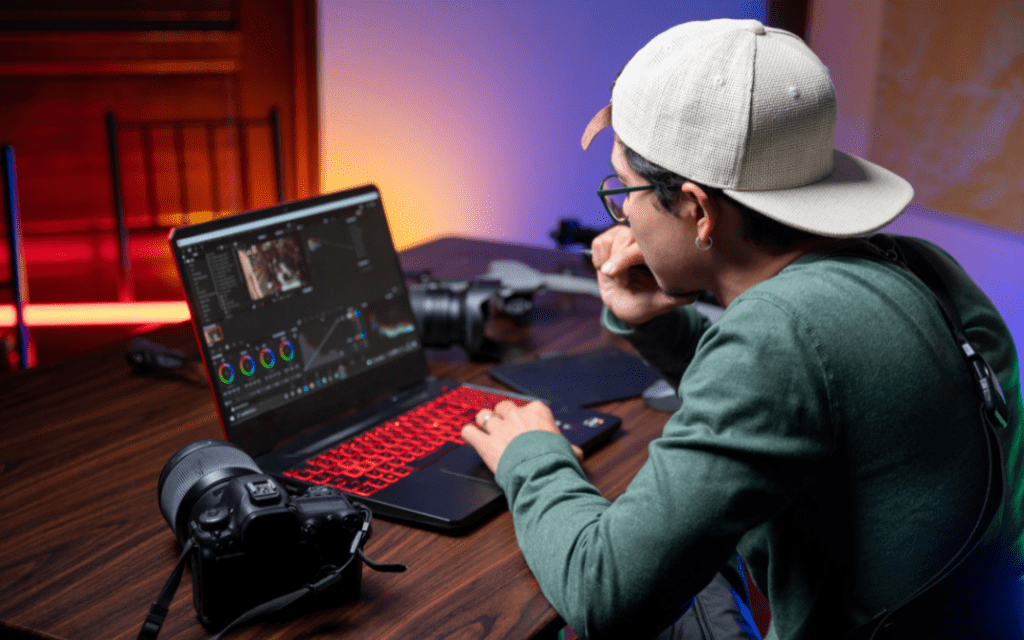 A freelance videographer editing his work by color grading the video in his room for a client of his